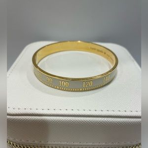 Kate Spade Tune In AM/FM white and gold bangle.